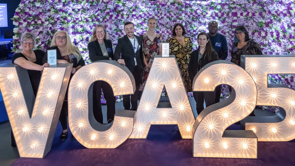 The Vice-Chancellor's award winning Network of Networks team standing behind the VCA 25 sign.